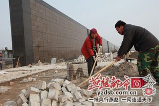 工人们正在铺设纪念墙塌陷便道