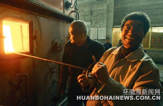 供热站工作人员刘挺松等一遍观测锅炉炉温一边接受记者采访