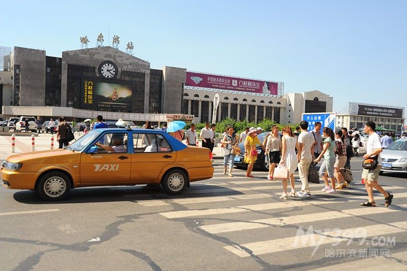 哈尔滨火车站前的一处斑马线前，个别车辆与行人抢行