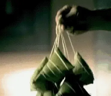 粽子特有的诱人气味扑面而来 剥开散发着清香的粽叶 糯米与叶壁间 迫