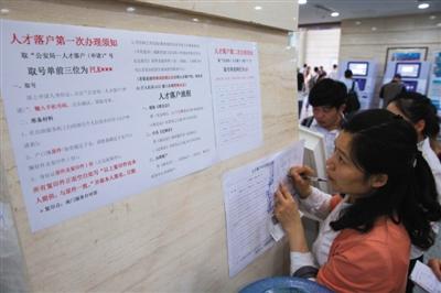 5月28日，南京市政务服务中心，一位市民在填表办理人才落户手续。近两年，多个城市为吸引人才出台政策降低了落户门槛。图/视觉中国