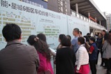 2015年3月21日，重庆搜房网3.21开年千人看房团整装出发。图为购房者在观看楼盘现场资料。
