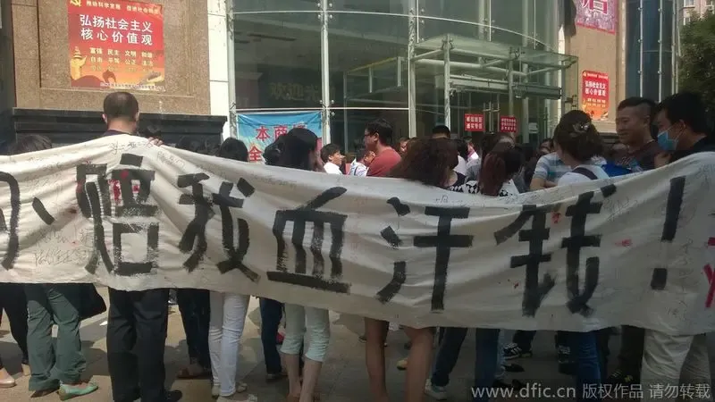 白底黑字的横幅上写有"正丰地产诈骗,陪我血汗钱!